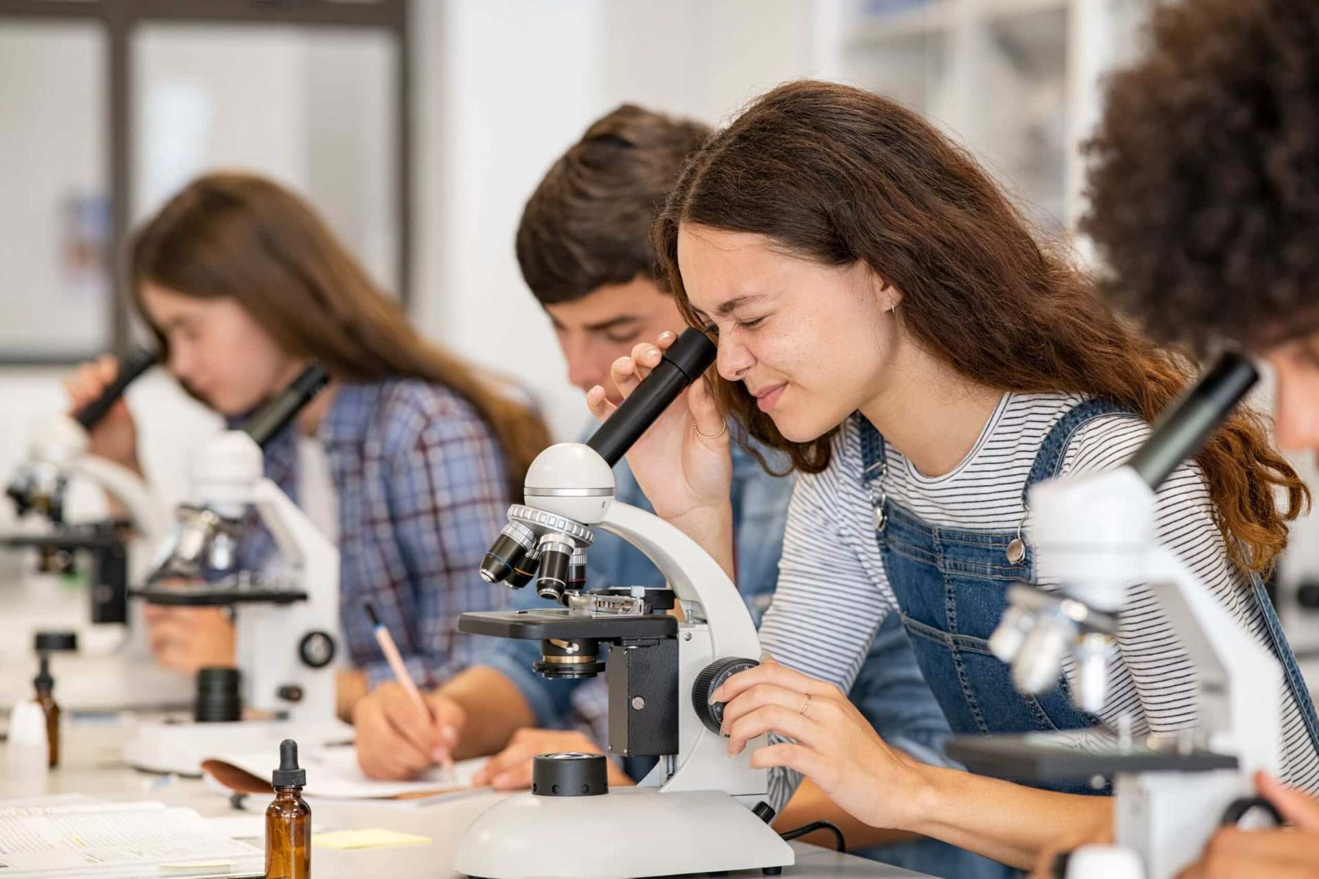 Students conducting science experiments with microscopes in a modern laboratory setting